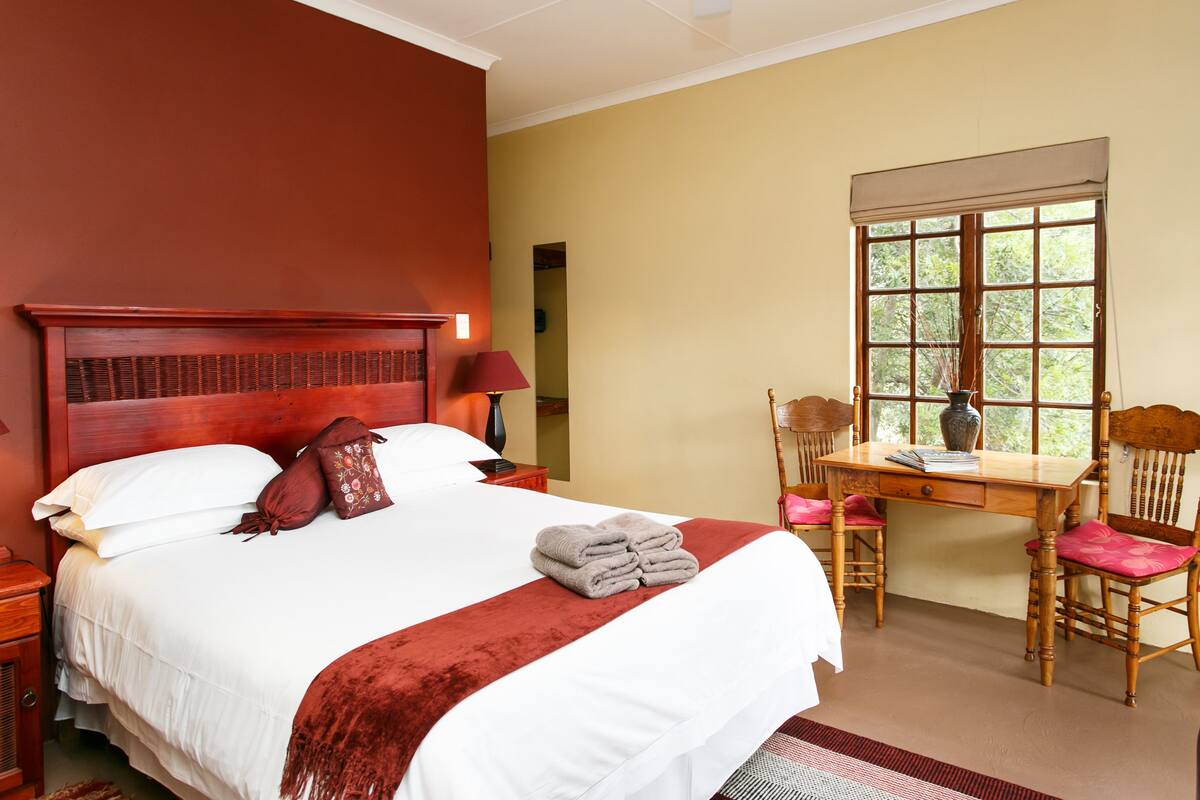 Ein Hotelzimmer mit einem großen Bett, einem Schreibtisch und einem Stuhl.