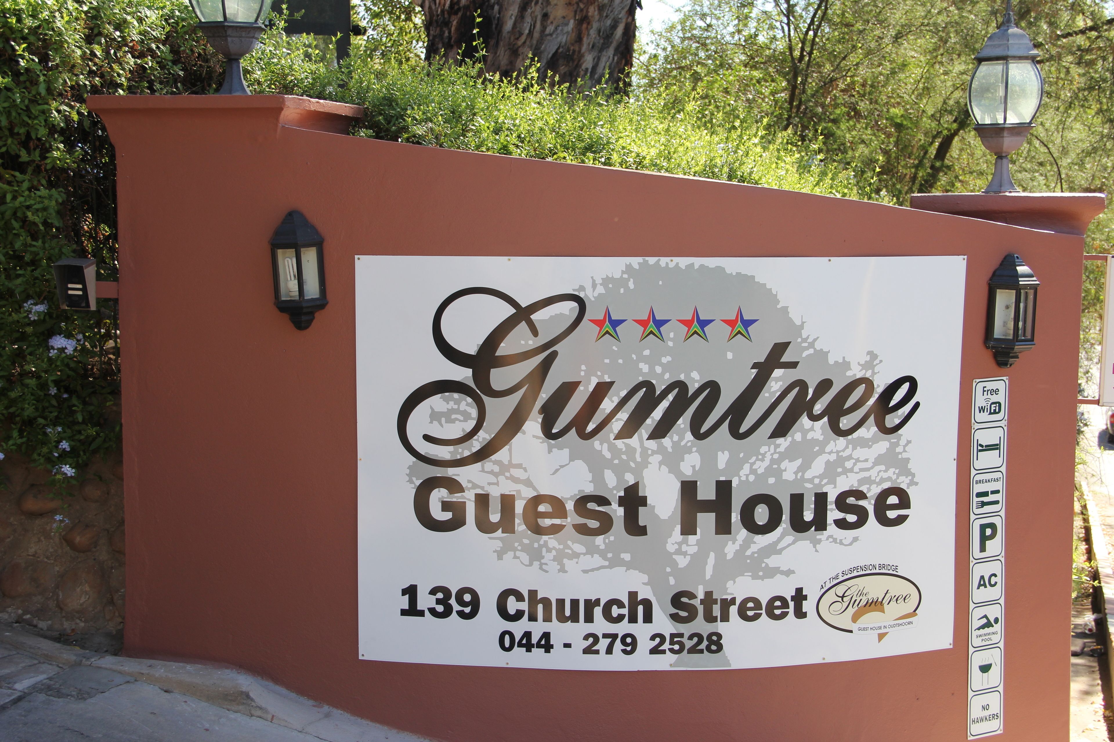 A sign for Gumtree Guest House, including the address and contact number.