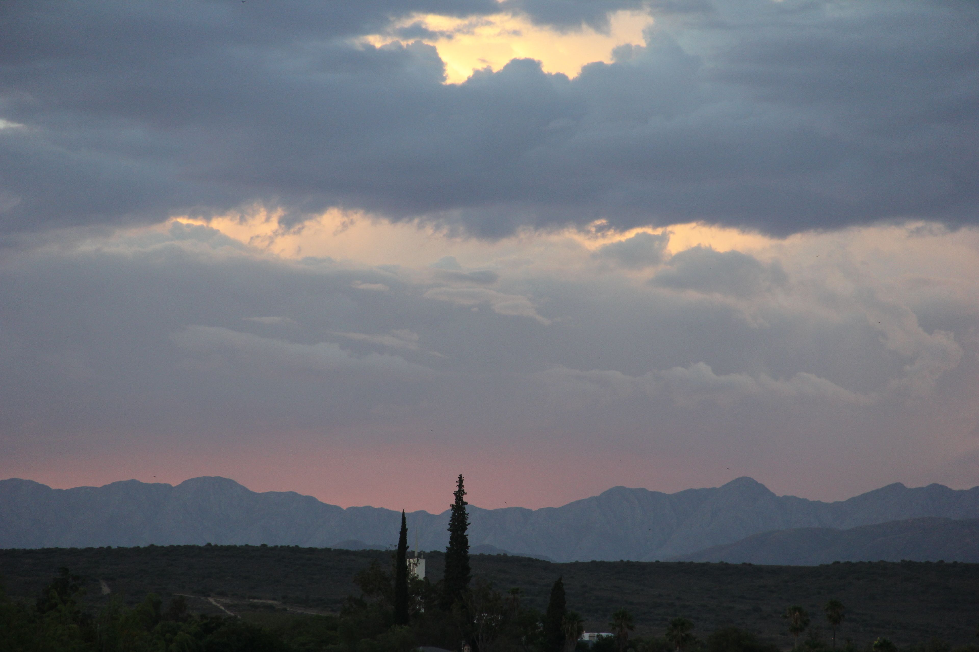 A mountainous landscape with a clear sky and a few clouds.