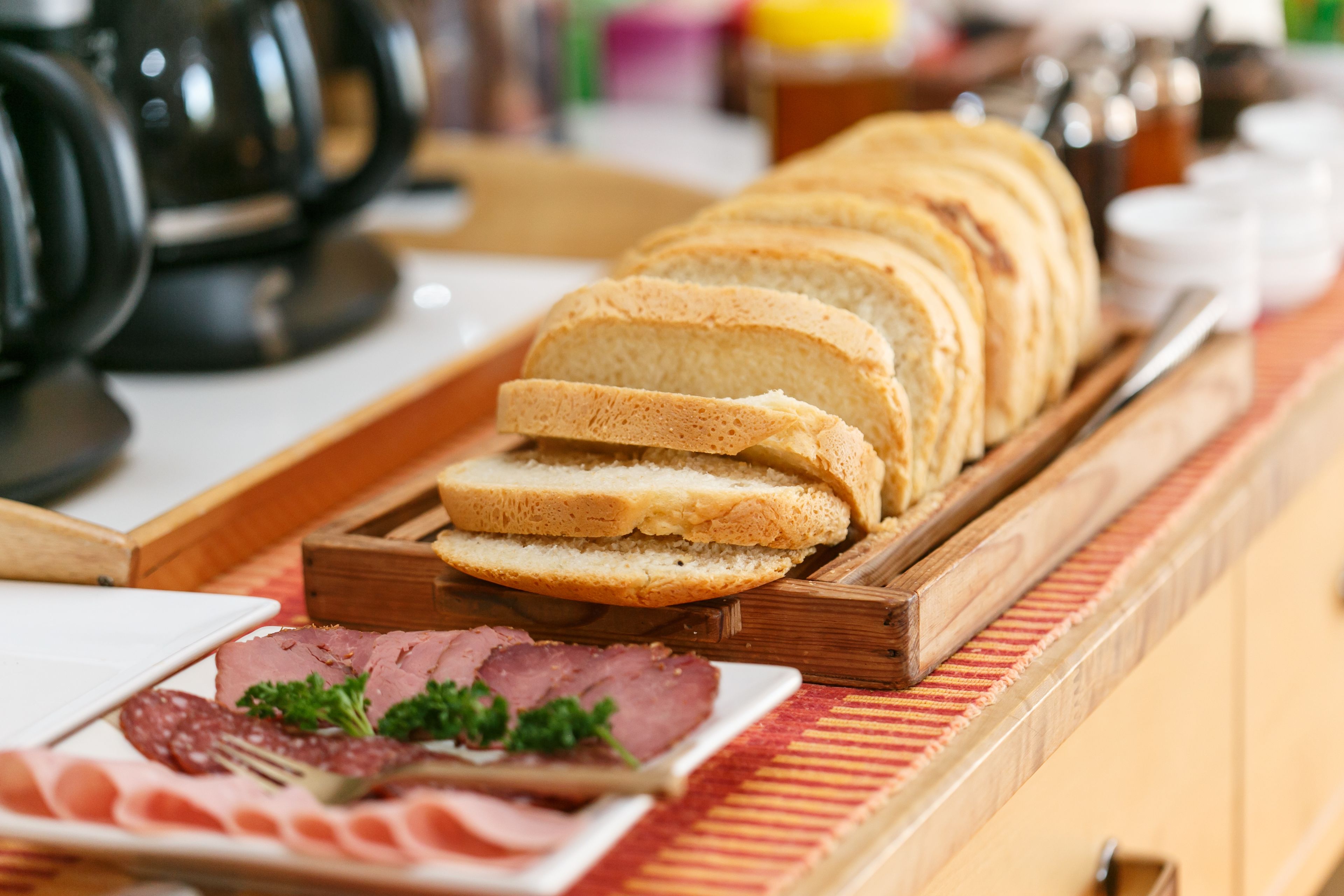 Ein Frühstücksbuffet mit Brot, Schinken und verschiedenen Käsesorten.