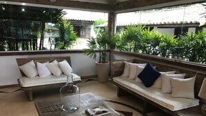 Un rincón acogedor con dos sofás de madera, una mesa de centro y plantas en macetas.