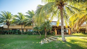 Un resort tropical con palmeras, un camino de piedra y un edificio con techo de tejas.