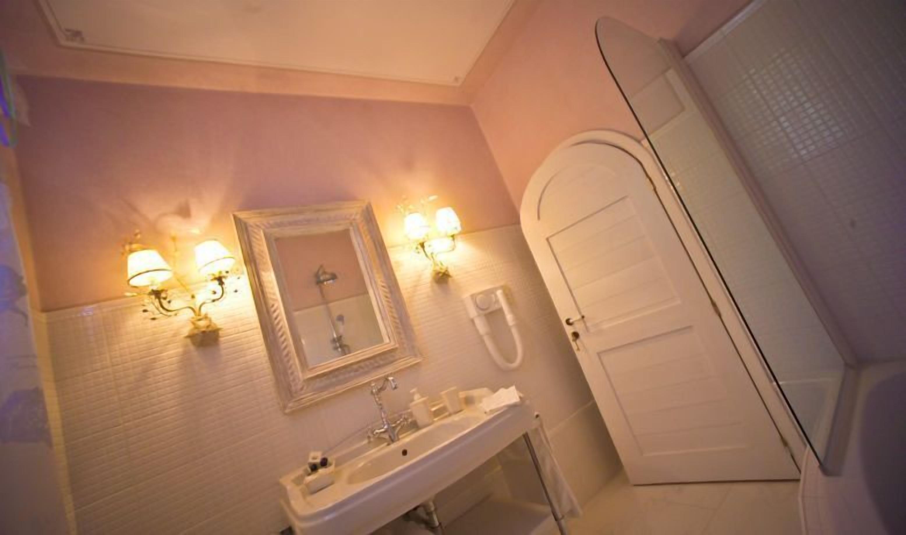 A bathroom with a sink, mirror, and shower.