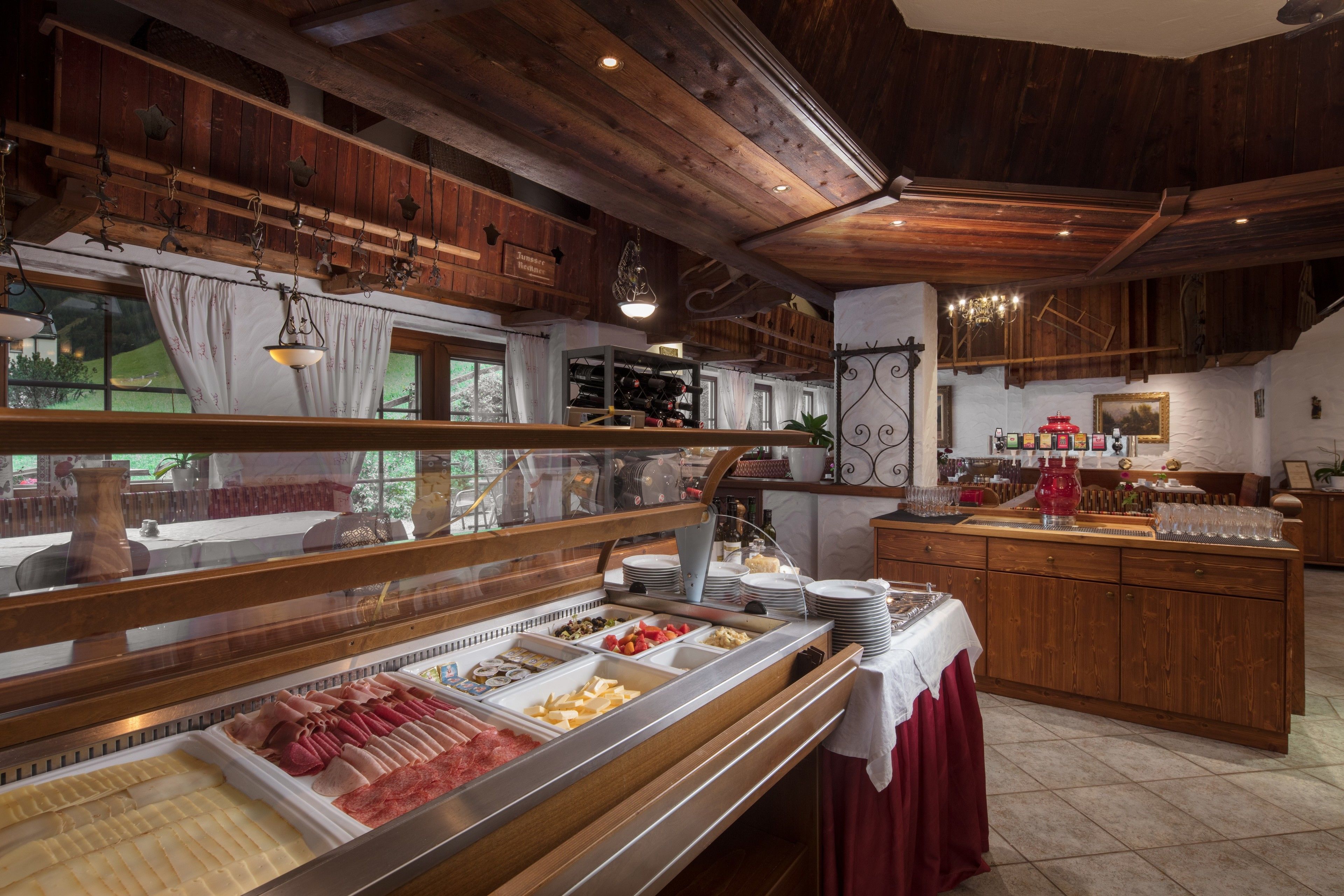 Un'area buffet con diverse opzioni alimentari, interni in legno e vista sull'esterno.