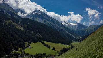 Eine Berglandschaft mit einem Tal, Häusern und blauem Himmel.