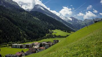 Un village de montagne aux maisons traditionnelles, sous un ciel dégagé, et niché dans une vallée.