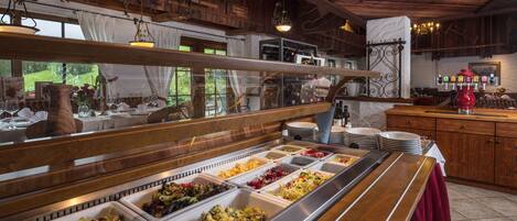 Un bufé con diversas opciones de comida, muebles de madera y una decoración rústica.