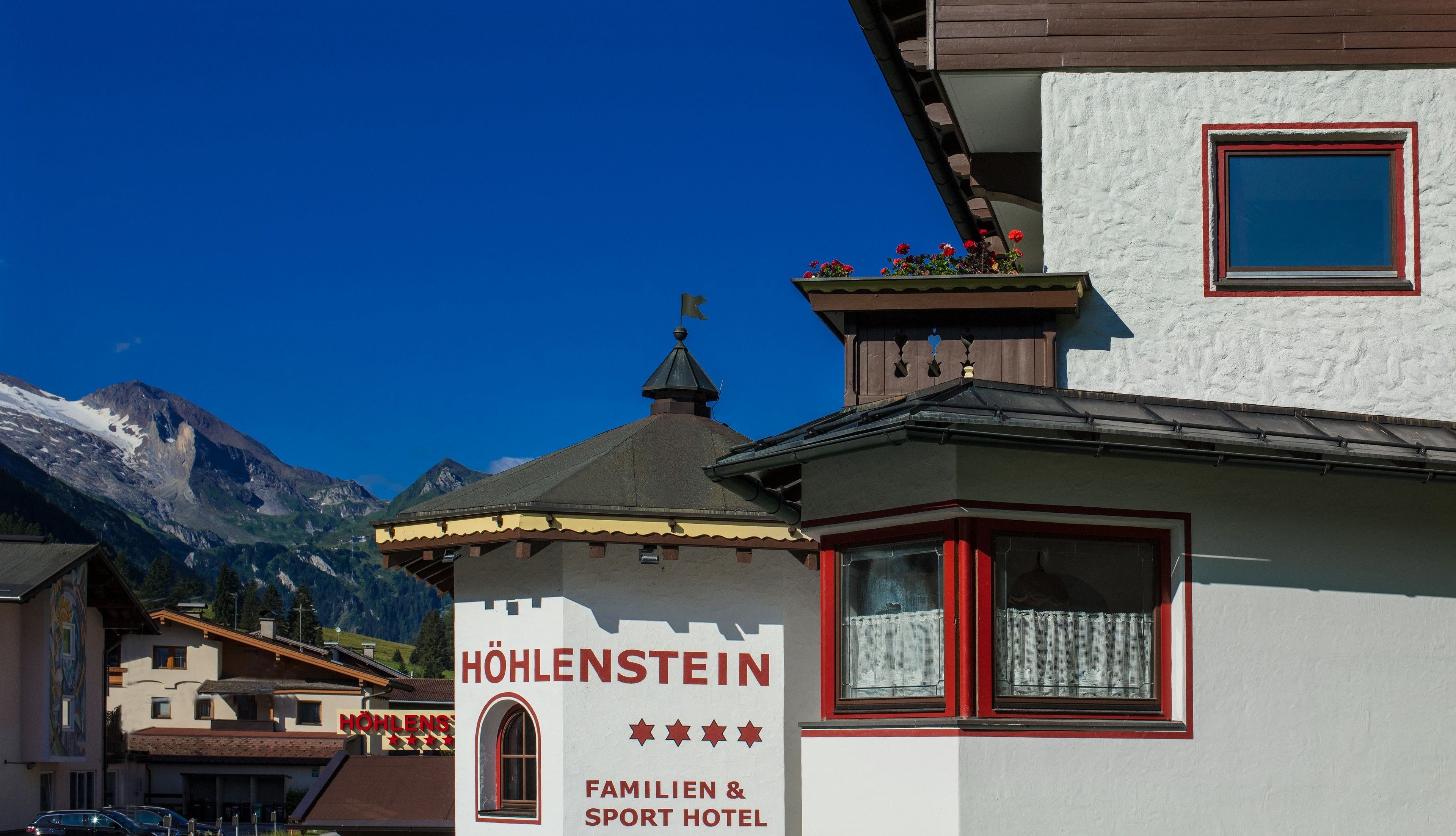 A hotel named "HÖHLENSTEIN" with a sign indicating it is a family and sport hotel.