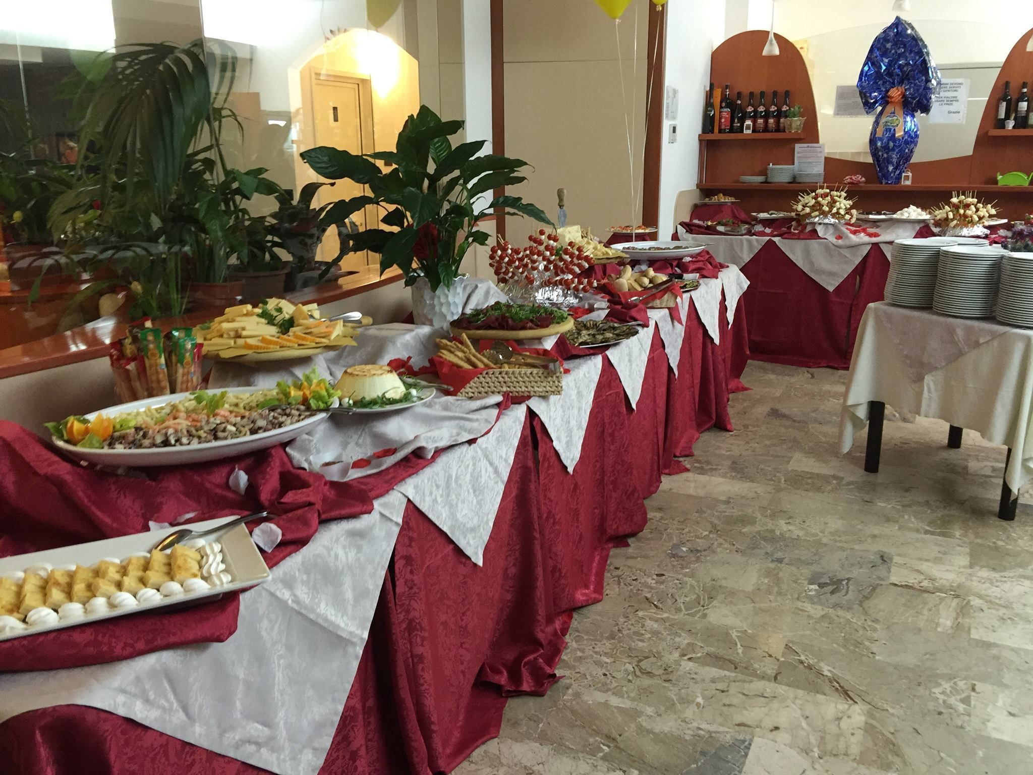 A buffet table with various food items and a potted plant.
