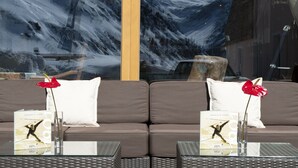Moderni sisustus, jossa on sohva ja kaksi pöytää. Kummassakin pöydässä on kirja, jonka nimi on ”Drinks & More” ja joka on julkaistu vuonna 1901.