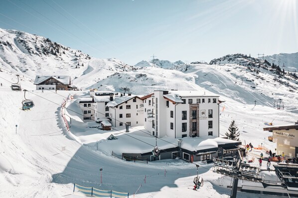 Un centro de esquí cubierto de nieve con varios edificios, incluyendo un hotel y un restaurante.