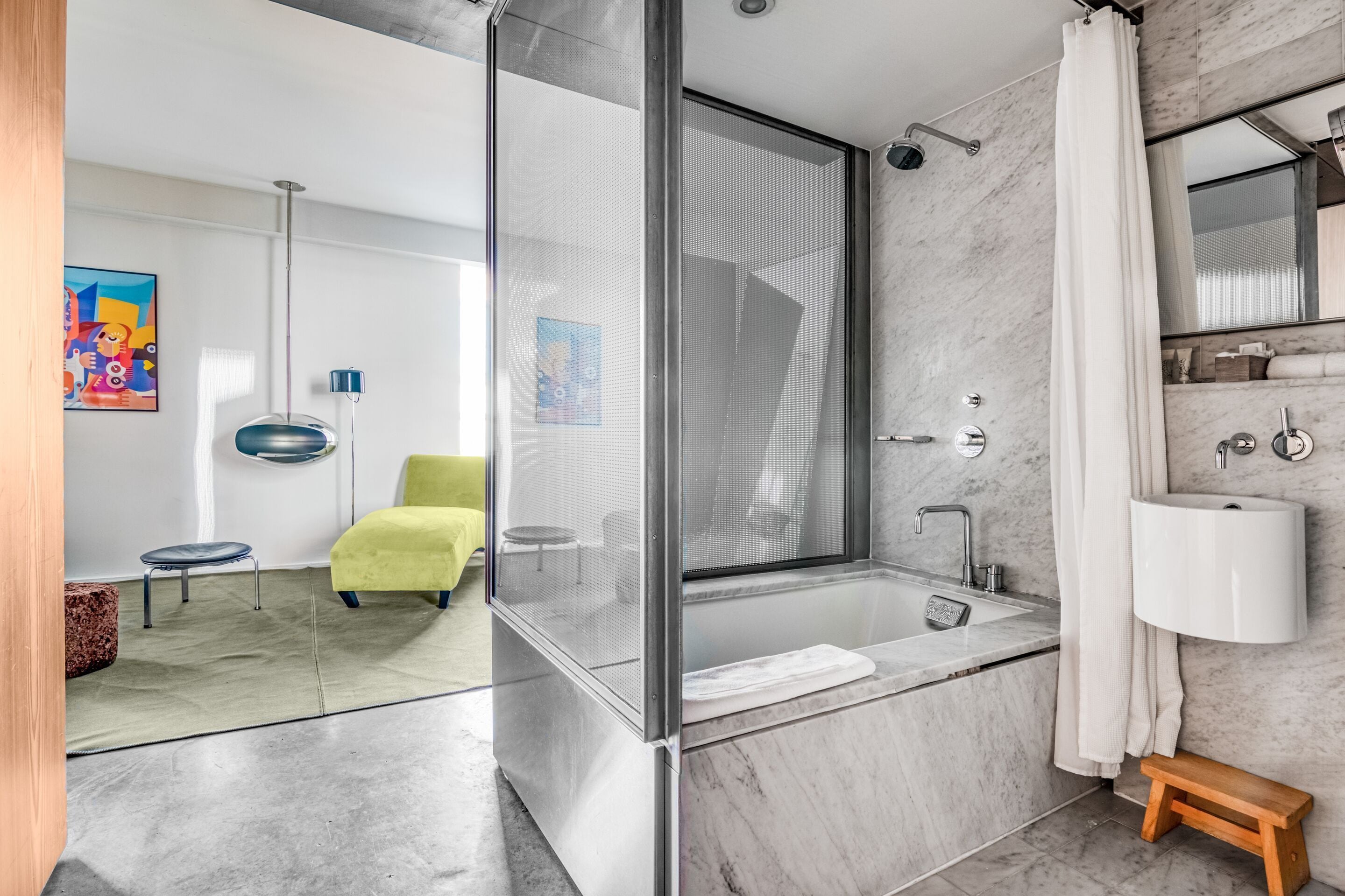 A modern bathroom with a glass-enclosed shower, a large bathtub, and a marble-tiled floor.