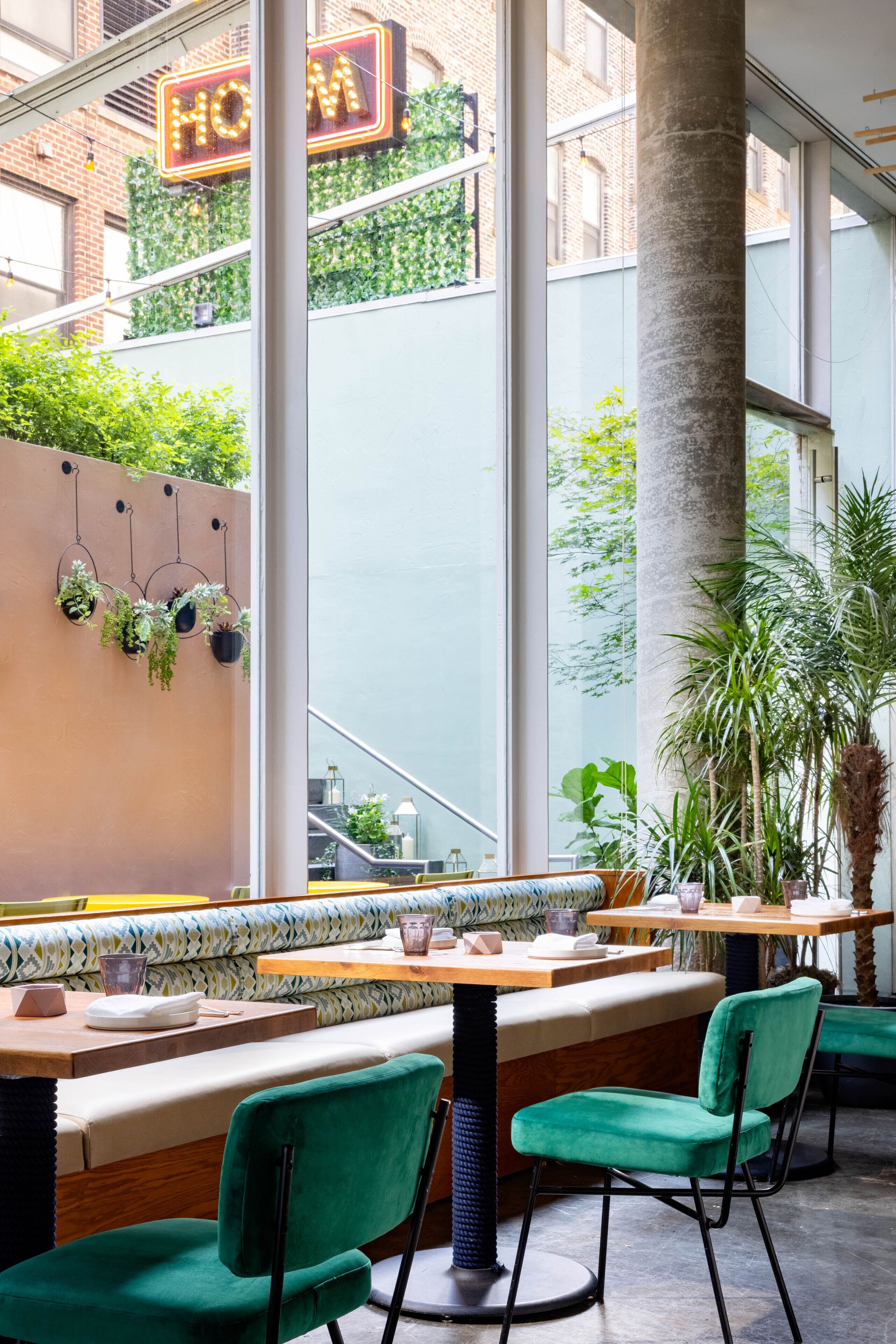 Ein Restaurant mit hoher Decke, großen Fenstern und Blick auf eine Straße.