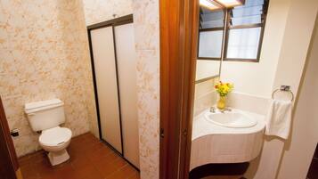 Un baño con inodoro, lavamanos y espejo.
