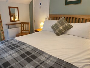 Cozy retreat with a large bed, nightstand, and comfortable chair.