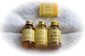 Bottles of bath and shower gel with ginseng sit on a towel, accompanied by a soap bar.