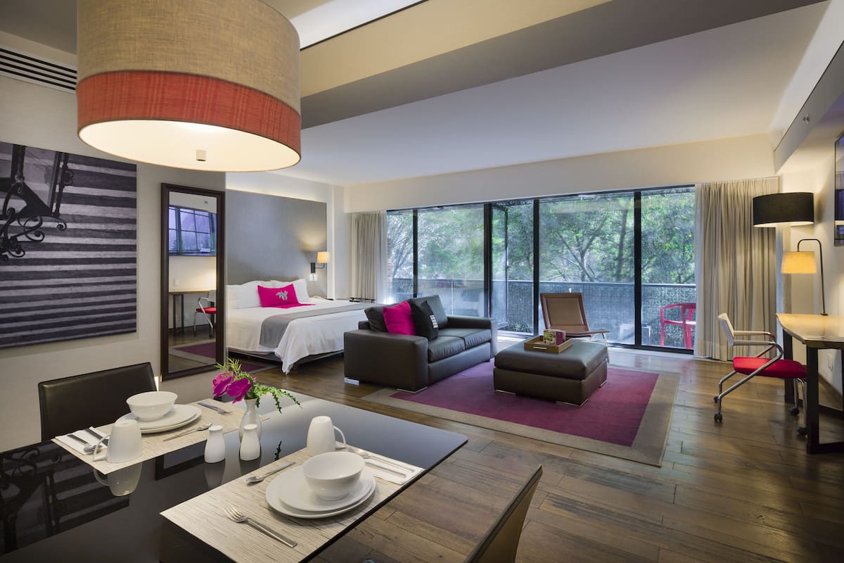 Ein modernes Hotelzimmer mit Bett, Sofa und Essbereich.