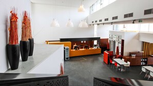 A spacious lobby with a reception desk, seating area, and large windows allowing natural light. - Kyriad Vienna Altmannsdorf (Vienna)