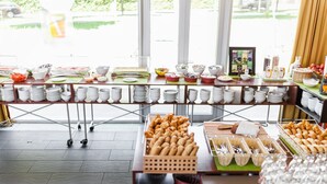 A buffet setup with various food items and utensils.