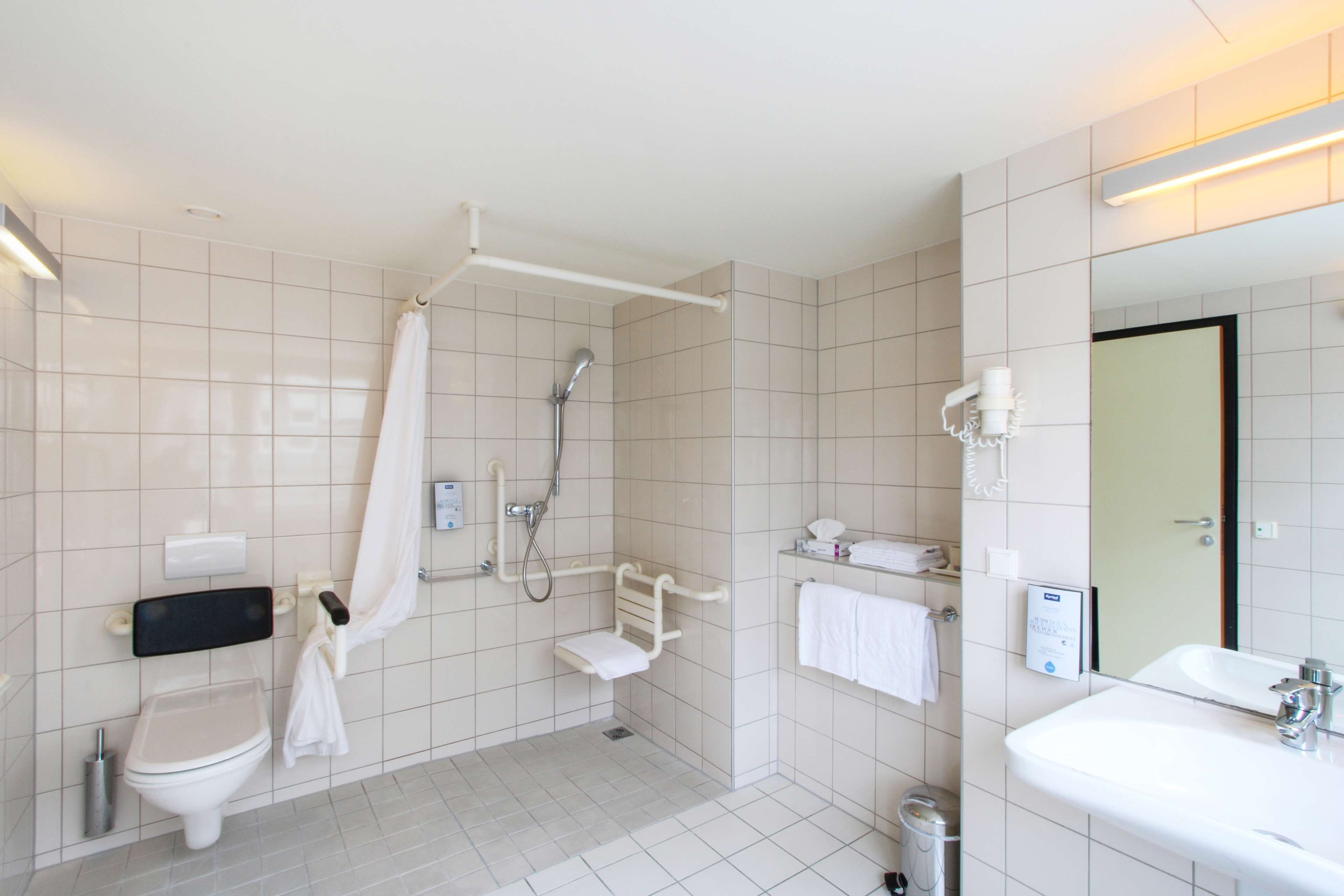 A modern bathroom with a toilet, shower, and sink.