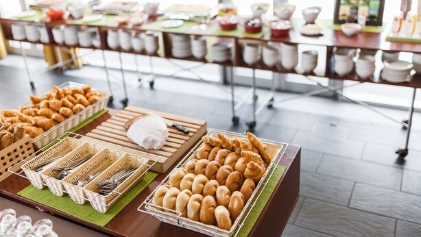A buffet setup with various food items and utensils. - Kyriad Vienna Altmannsdorf (Vienna)
