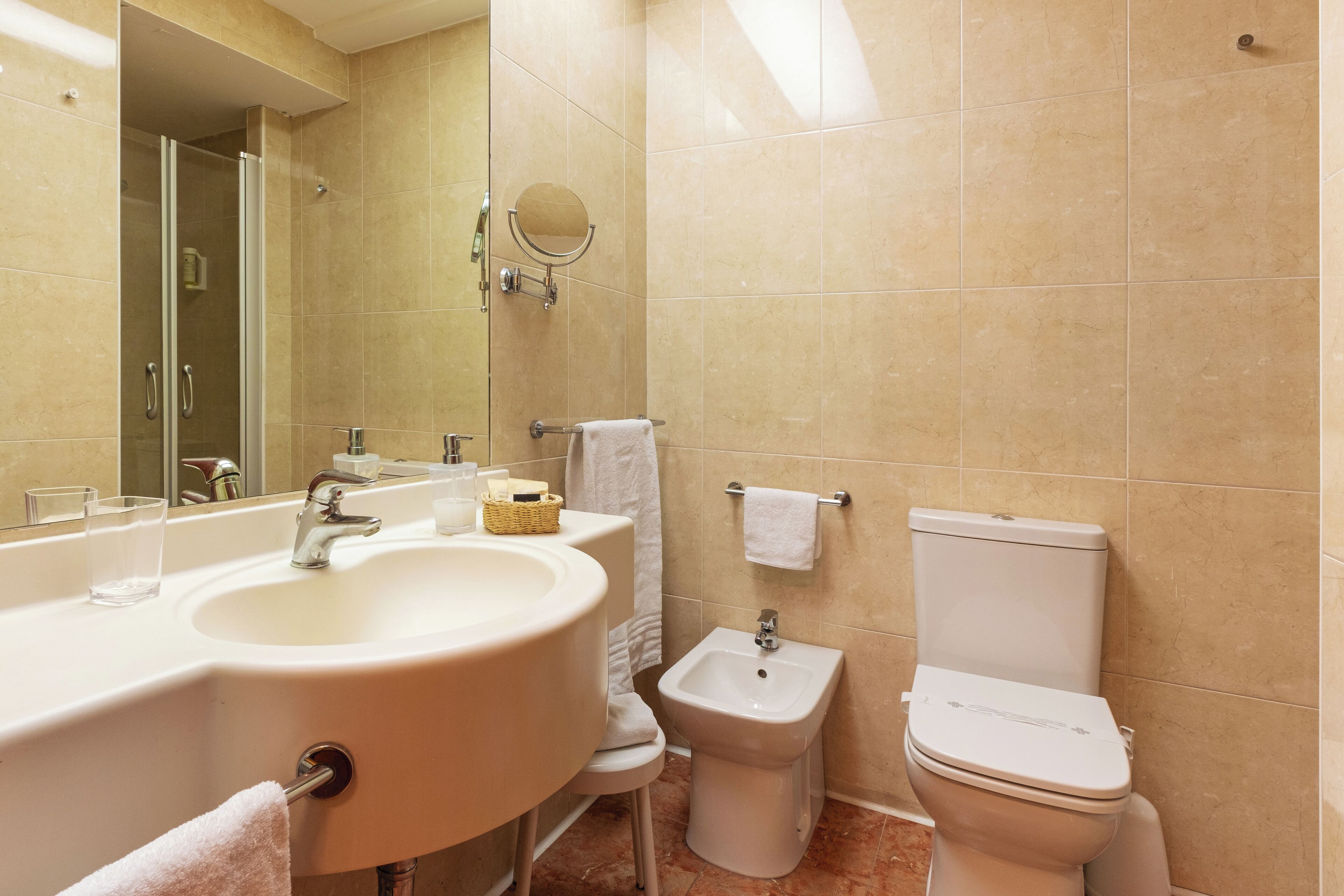 Ein Badezimmer mit Waschbecken, Bidet, Toilette und Spiegel.