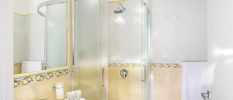 Une salle de bain avec une douche à parois de verre, un lavabo et un miroir.