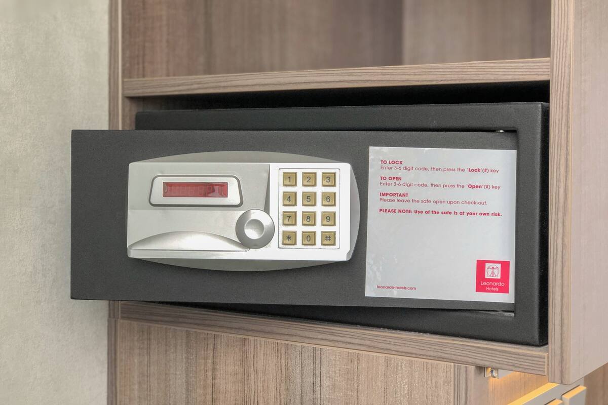 Ein Hotelsafe mit Tastatur und einem Zettel, der dazu auffordert, einen 3-stelligen Code zur Ver- oder Entriegelung einzutippen.