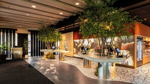 Un hall con mostrador de recepción, zona de estar y una vitrina.