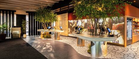A lobby with a reception desk, seating area, and a display case.