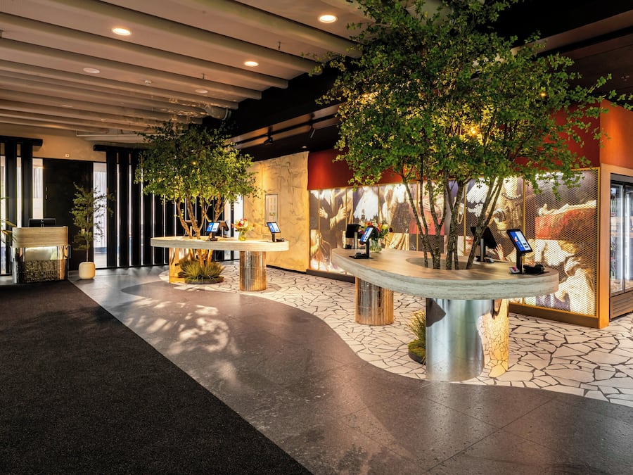 A lobby with a reception desk, seating area, and a display case.