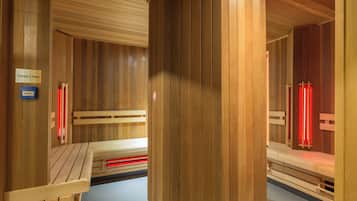 Eine Sauna mit Holzbänken und einem Schild, das einen Notrufknopf kennzeichnet.