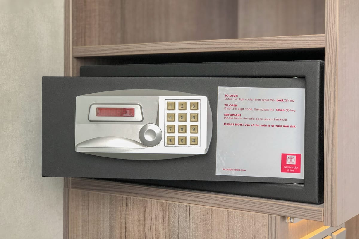 A hotel safe with a keypad and a note instructing to enter a 3-digit code to lock or open.