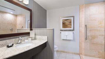 A modern bathroom with two sinks, a large mirror, a shower area, and a framed artwork on the wall.