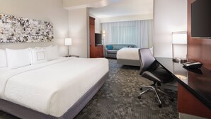 A hotel room with a large bed, a desk with a computer, a TV, and a painting on the wall. - Courtyard by Marriott Pittsburgh Washington/Meadow Lands (Washington)