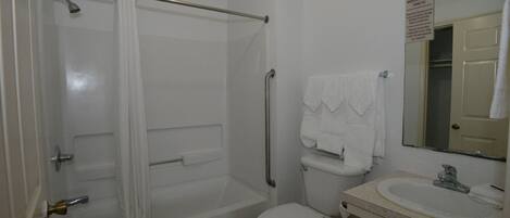 A bathroom with a bathtub, toilet, and sink.
