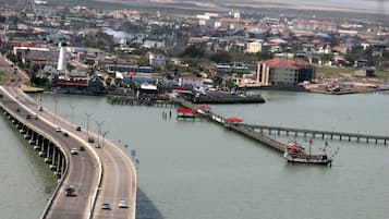 Paesaggio costiero con un ponte importante, un faro e un molo che si protende nell'acqua.