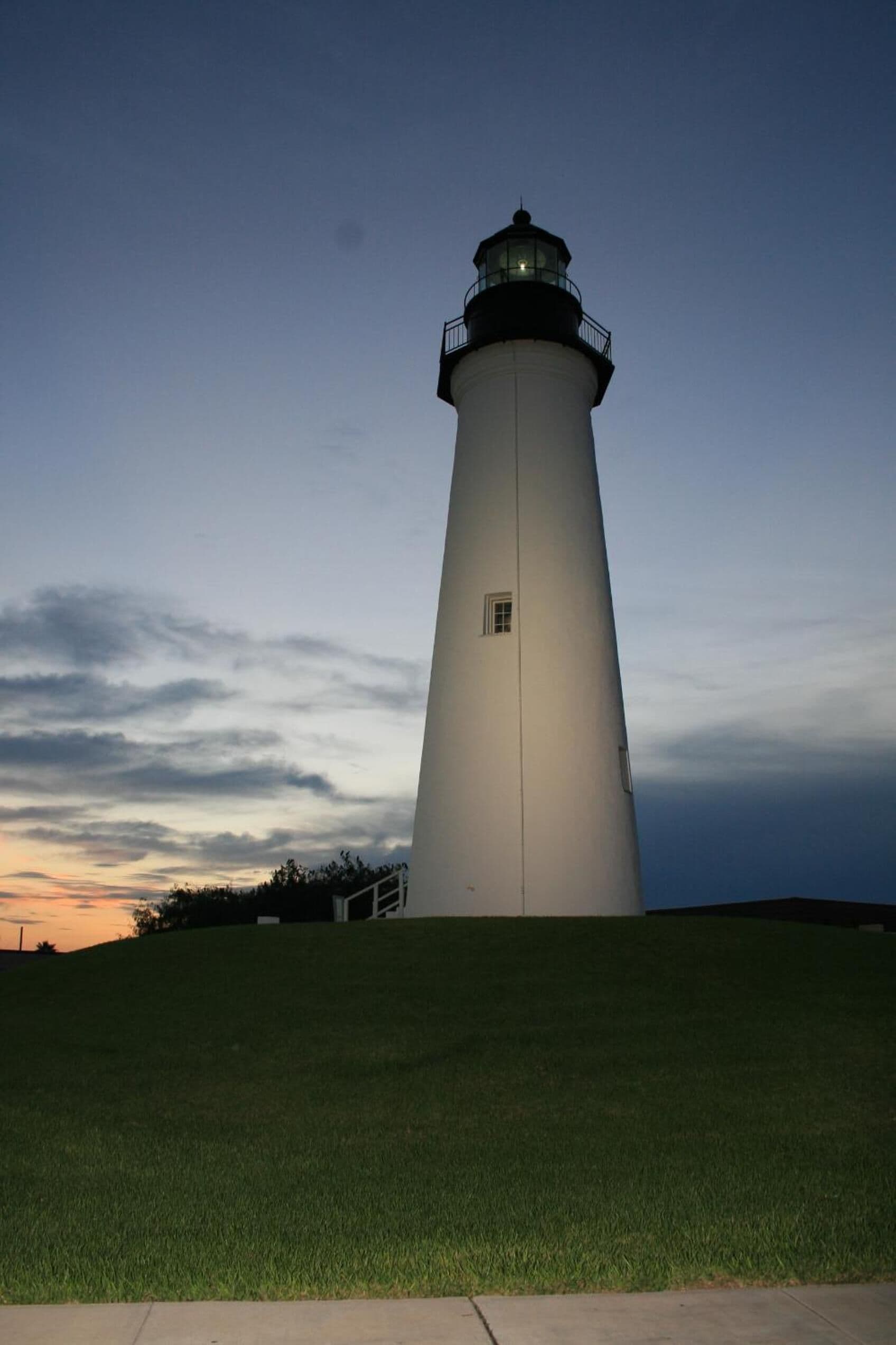 A lighthouse with a conical shape, a small window near the top, and a light at the top.