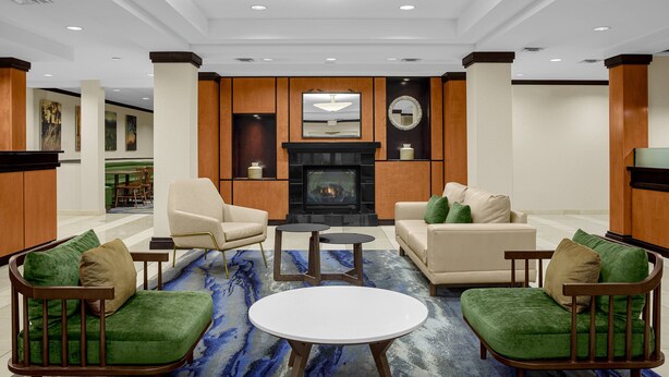 A spacious lobby with a fireplace, comfortable seating, and a large rug. - Fairfield Inn & Suites by Marriott Paducah (Paducah)
