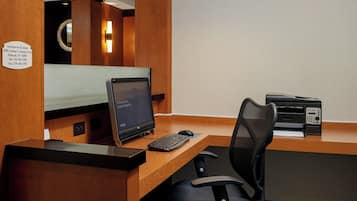 Un comptoir d’accueil équipé d’un ordinateur, d’une imprimante et d’un panneau indiquant l’emplacement du Fairfield Inn & Suites.