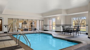 An indoor swimming pool with a clear view of the adjacent room, a dining area, and a window with a view of the outdoors. - Fairfield Inn & Suites by Marriott Paducah (Paducah)
