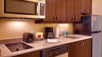 A kitchenette with a microwave, toaster, coffee maker, and refrigerator.