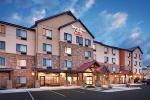 A TownePlace Suites hotel with a stone facade, multiple windows, and a parking lot. - TownePlace Suites by Marriott Elko (Elko)