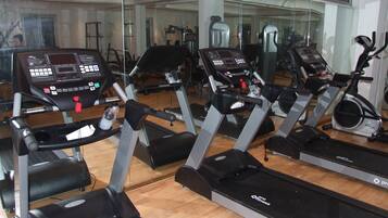 Academia com várias esteiras de corrida Pro Fitness, espelhos e equipamentos de ginástica.