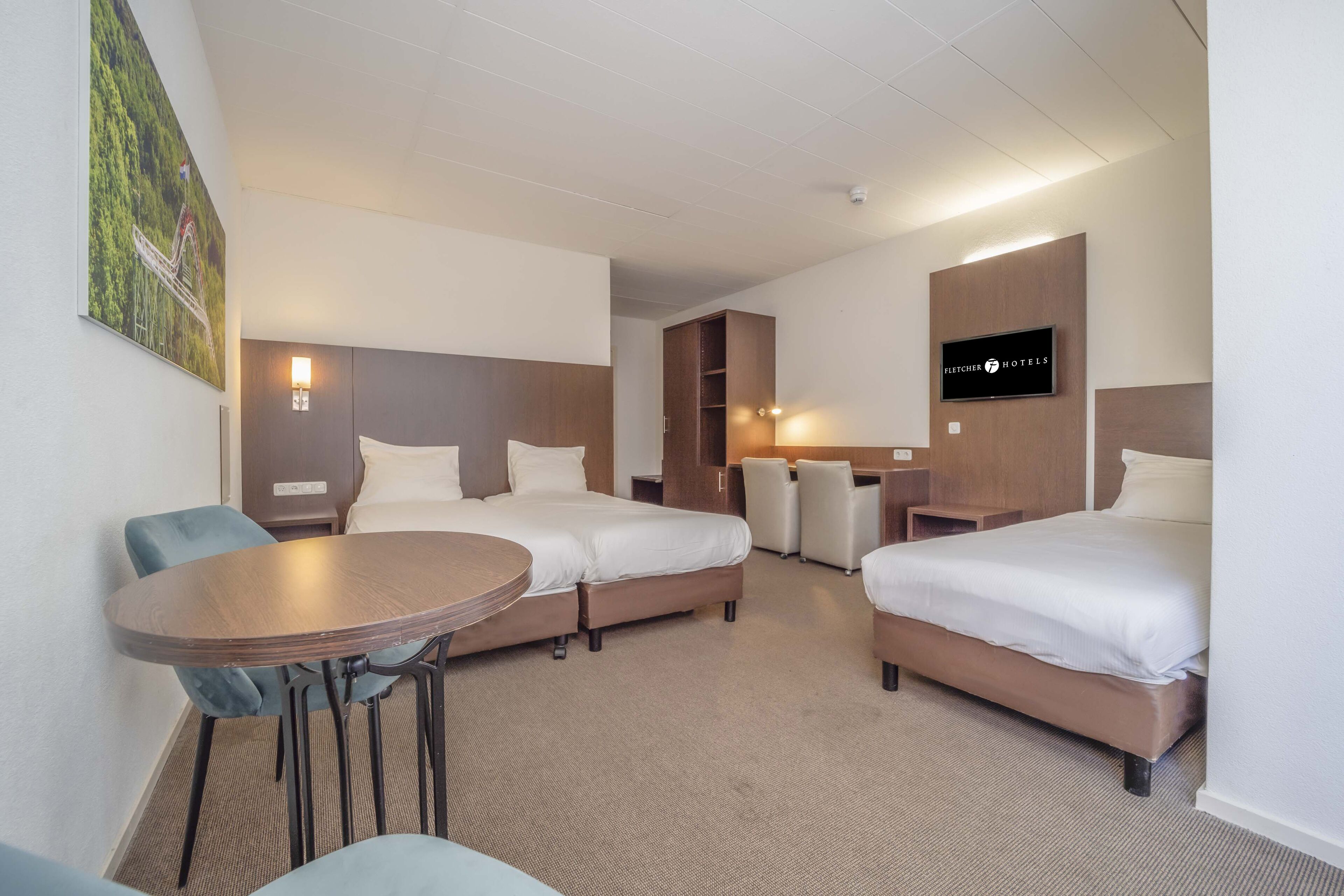A hotel room with two beds, a desk, a chair, and a television.