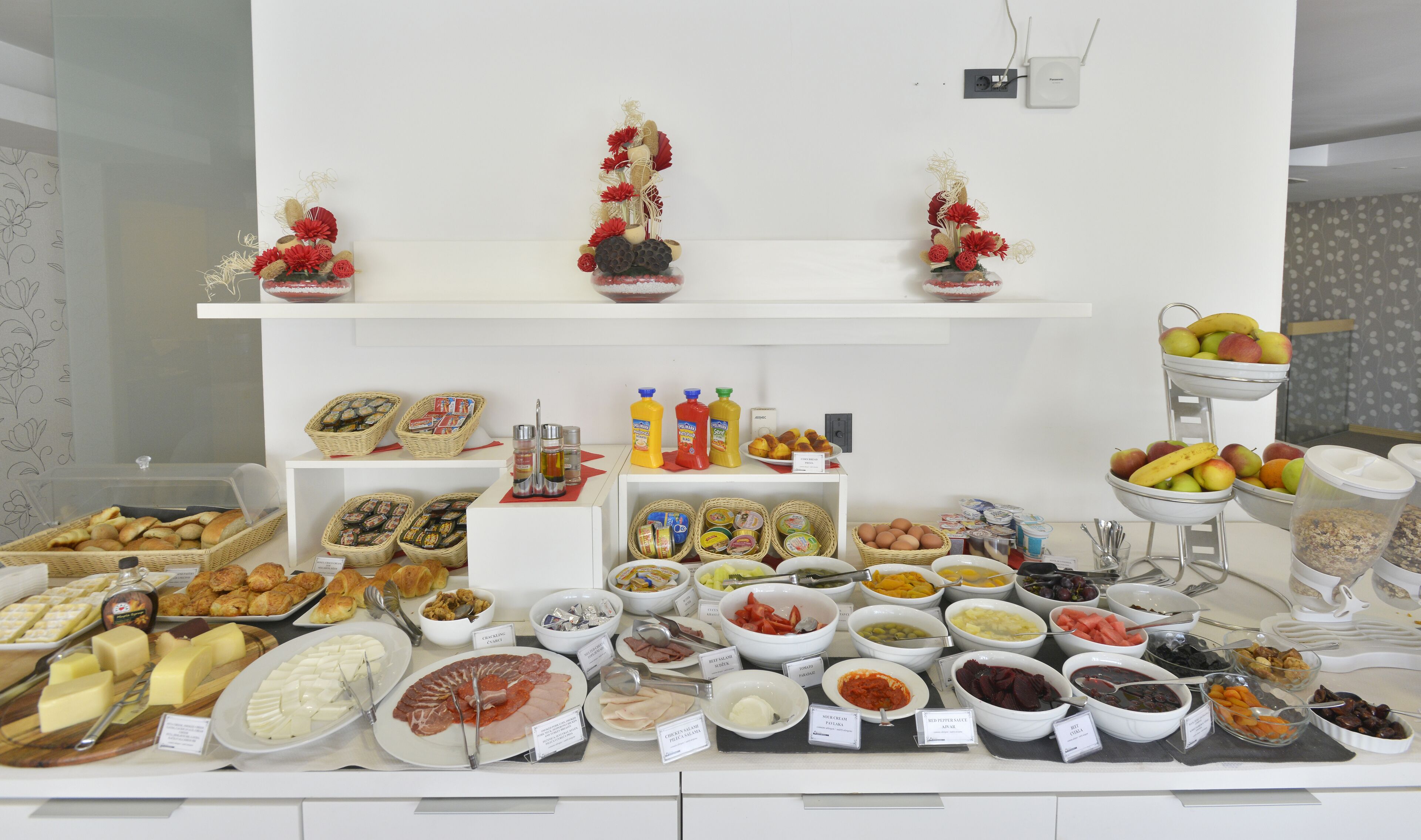 A buffet with various food items and condiments.