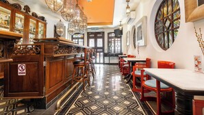 L’intérieur d’un restaurant, avec un espace bar, des meubles en bois et un revêtement de sol à motifs.
