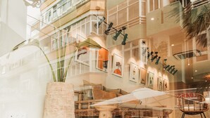 A modern interior with a high ceiling, wooden furniture, and a large vase. - Hotel Aloe Canteras (Las Palmas de Gran Canaria)