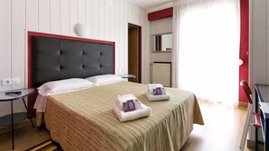 Une chambre d’hôtel avec un grand lit, une table de chevet, une chaise et un bureau.