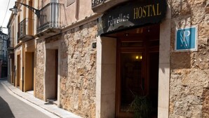 Un bâtiment en pierre sur lequel on peut lire l’inscription « Hostal Fabrellas ».